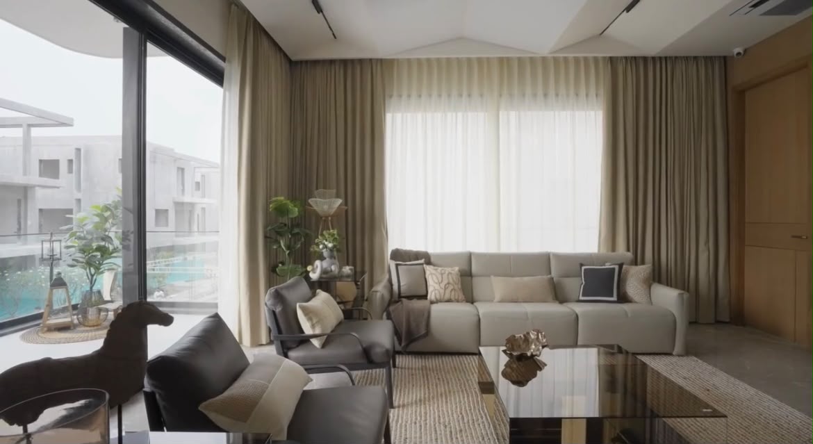Living room opening to a terrace with pool view and layered natural fabrics